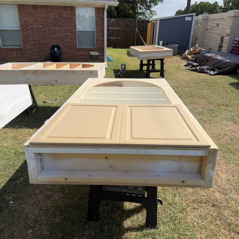 Unfinished arched retail cabinetry assembled outdoors during fabrication